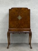 A mid century burr walnut early Georgian style drinks cabinet with fitted and mirrored interior. H.