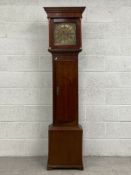 A Georgian mahogany and elm longcase clock having a moulded cornice over a gilt metal dial bearing