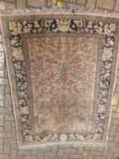 A Persian style rug having a central tree of life motif over a pale pink abrash ground within