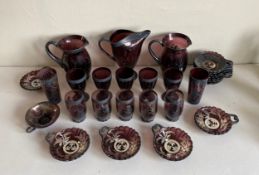 A large set of Venetian cranberry glass to include three pitchers, twelve glasses, twelve dishes and