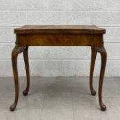 An early Georgian style walnut card table having a book matched and crossbanded fold over top