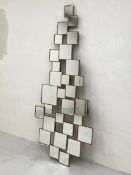 A contemporary wall mirror comprised of a multifaceted collage of small irregular and offset