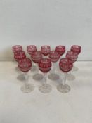 A set of twelve Bohemian cut cranberry sherry glasses. H.12cm