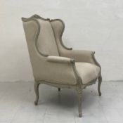 A contemporary Louis XV style wingback armchair having a shaped and carved top rail with cushioned