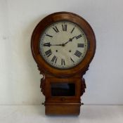 An early 20th century drop dial wall clock having an enamelled dial bearing Roman numerals in a