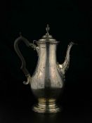 A hallmarked silver lidded coffee pot marked London 1897 having a cup and cover finial over a