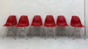 A set of six moulded dining chairs raised on 'Eiffel Tower' chrome supports designed by Charles