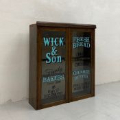An early 20th century oak shop display cabinet for Wick & Son Bakers, Richmond having a moulded