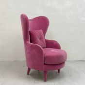 A contemporary Kay armchair by La Fibule having a shaped wing back and arms over a circular