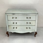 An Art Deco style mirrored chest of drawers having a rectangular top above three long drawers with