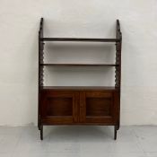 A 19th century mahogany wall hanging open bookcase having three adjustable shelves over a panelled