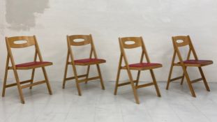 A set of four mid century beech folding dining chairs each having a curved openwork back over a