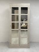 A contemporary painted pine wardrobe having a moulded cornice over two long doors with mirrored