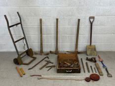 A mixed collection of vintage tools to include a sack barrow, pick axes, a shovel, tape measures and