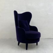 A contemporary Kay armchair by La Fibule having a shaped wing back and arms over a circular