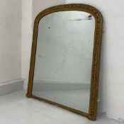 A 19th century giltwood overmantle mirror having its original arched plate in an egg and dart