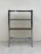 A mid century chrome and smoked glass open bookcase or shelving stand having three shaped shelves