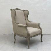 A contemporary Louis XV style wingback armchair having a shaped and carved top rail with cushioned