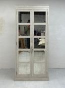 A contemporary painted pine wardrobe having a moulded cornice over two long doors with mirrored