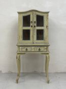 A late 19th century painted French display cabinet on stand having a moulded serpentine pediment