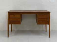 A 1960s Danish teak desk having a rectangular top over an arrangement of six short drawers raised on