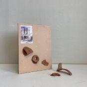 A mixed media composition displaying fragments of terracotta along with an image of the