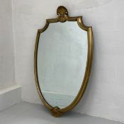 A French 19th century style wall mirror having a shaped plate in a moulded and gilt shield shaped