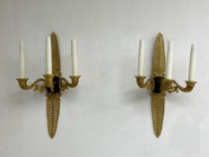 A pair of French Empire style brass wall sconces each having an openwork acanthus leaf plate with