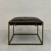 A vintage Hanbel footstool having a distressed leather buttoned seat set into a simple gilt metal