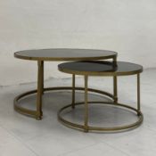 A vintage nest of two tables each having a circular black perspex top set into a brass frame. H.34.5