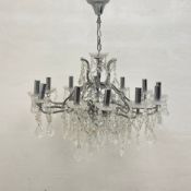 A vintage chandelier having a tubular chrome armature with twelve scrolling branches draped with cut