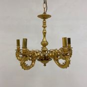 A 20th century brass chandelier having a turned and moulded baluster form stem with four scrolling