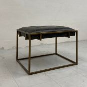A vintage Hanbel footstool having a distressed leather buttoned seat set into a simple gilt metal