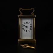 A C.1900 French brass carriage clock having a shaped swing handle with a moulded top over the