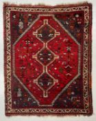 A vintage Persian style Shiraz carpet having three central diamond lozenge medallions surrounded