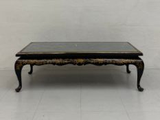 An early 20th century black lacquered Chinoiserie coffee table having a rectangular top with gilt