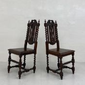 A pair of 19th century oak high-back hall chairs each having a carved leaf cresting and openwork
