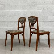 A pair of contemporary Croatian stained ply chairs each having a curved top rail with an upholstered