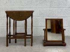 A small early 20th century oak drop leaf table having a circular thumb moulded top raised on a