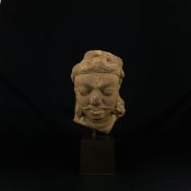 An Indian possibly Gupta period carved red sandstone figural bust or head raised on a museum style