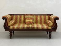 A 19th century Empire style scroll-end sofa or settee having a moulded mahogany back and arms over a