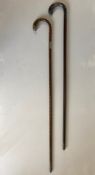 Two walking sticks or canes to include one with Birmingham 1908 silver hallmarked mounts with