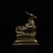 A 19th century Indian brass figural statue depicting a recumbent Nandi; the sacred bull and mount of
