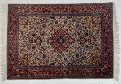 A Persian style Sarouk rug having a central diamond lozenge medallion surrounded by spandrels and