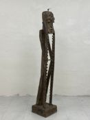 A tribal African style carved CD rack of figural form with a stylised head and an elongated body