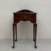 A Georgian walnut side table having a shaped gallery back with a quarter-veneered and cross-banded