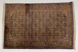 An Indo-Persian Herati carpet having a an all-over repeating patterned field in greens, oranges