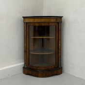 A 19th century bow-fronted rosewood corner cabinet having an ebonised cornice with a gilt metal trim