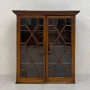 A 19th century mahogany bookcase having a moulded cornice over two astragal glazed cabinet doors