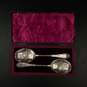 A pair of late 19th century silver hallmarked fruit spoons each having a scrolling floral repousse